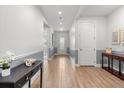 Bright hallway with wood floors, neutral paint, and stylish console table at 2413 Park Ridge St, Apopka, FL 32712