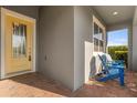 Inviting porch with brick flooring, seating and a bright yellow front door at 2413 Park Ridge St, Apopka, FL 32712