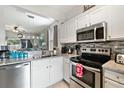 Modern kitchen with granite counters, stainless steel appliances, and white cabinets at 302 Calabria Ave, Davenport, FL 33897