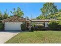 Charming single-story home featuring a stone accent wall and well-maintained lawn at 412 Short Dr, Poinciana, FL 34759