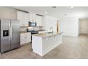 Modern kitchen with white cabinets, stainless steel appliances, granite countertops, and a kitchen island at 4973 Kaia Ave, Winter Haven, FL 33884