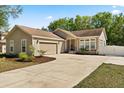 Charming one-story home featuring a well-manicured lawn, attached garage, and inviting front entrance with a wide driveway at 780 Old Mount Dora Rd, Eustis, FL 32726