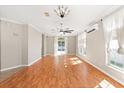 Bright and airy living room featuring hardwood floors, multiple windows, and a sliding glass door to the outside at 780 Old Mount Dora Rd, Eustis, FL 32726