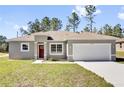 Charming single-Gathering home with a red front door, one car garage and green lawn at 12781 Sw 86Th Circle, Ocala, FL 34473
