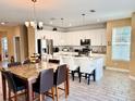 Bright kitchen with white cabinetry, granite countertops, large island with seating, and stainless steel appliances at 1337 Ash Tree Cv, Casselberry, FL 32707