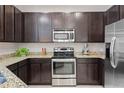 Modern kitchen featuring dark cabinets, stainless steel appliances, and granite countertops at 13605 Eridanus Dr, Orlando, FL 32828