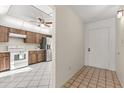 Hallway leading into the kitchen, featuring white appliances and wooden cabinets at 15 Escondido Ct # 145, Altamonte Springs, FL 32701