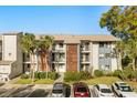 Exterior shot of condominium featuring tropical landscaping, balconies, and parking at 15 Escondido Ct # 145, Altamonte Springs, FL 32701