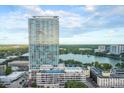 Stunning aerial view of a modern high-rise condo overlooking a serene lake and lush greenery at 150 E Robinson St # 807, Orlando, FL 32801
