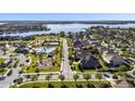 Community aerial view showcasing a pool, playground, tennis courts, and a scenic lake at 16003 Tangerine Blossom Way, Winter Garden, FL 34787