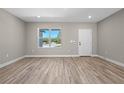Bright and open living room with laminate flooring and a large window offering plenty of natural light at 18 Pine Pass Ln, Ocala, FL 34472