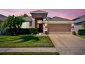 Inviting single-Gathering home featuring a well-manicured lawn, mature landscaping, and an attached two-car garage at 2519 Cypress Trace Cir, Orlando, FL 32825