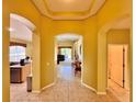 Open hallway featuring tile flooring and arched doorways to the kitchen, living room, and bedroom at 2519 Cypress Trace Cir, Orlando, FL 32825