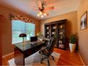 A cozy home office with a sleek black desk, leather chair, and built-in bookcase at 2519 Cypress Trace Cir, Orlando, FL 32825