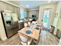 Cozy dining area with gray cabinets, stainless steel appliances, and a rustic wooden table at 3083 Pirate Way, Kissimmee, FL 34747