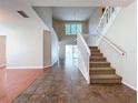 Bright foyer with tile and wood flooring, staircase, and view to the backyard at 358 Morning Creek Cir, Apopka, FL 32712