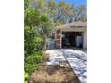 View of the garage, showing a glimpse inside and a pathway with lush greenery at 511 Terrier Way, New Smyrna Beach, FL 32168