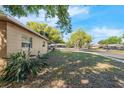 A home's front yard featuring mature trees, landscaping, and view of the neighborhood at 5386 Mustang Way, Orlando, FL 32810