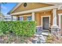 Charming covered front porch with manicured hedge and stone details at 5910 Windsong Oak Dr, Leesburg, FL 34748