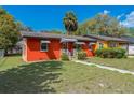 Front exterior view of a colorful single-story home with a well-maintained lawn at 612 Kensington St, Eustis, FL 32726
