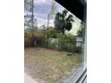 The backyard featuring lush greenery and a mix of trees, plants and a view through a large window at 6130 Gamble Dr, Orlando, FL 32808