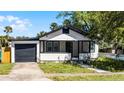 Quaint home displaying the yard, single car garage, and front porch with inviting curb appeal at 819 State Ave, Daytona Beach, FL 32117
