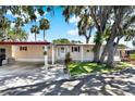 Charming single-story home with mature landscaping, a welcoming front door, and convenient carport at 105 Canal Vw, Eustis, FL 32726