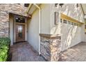 Stunning home exterior features a stone entryway, two-car garage, and brick-paved driveway at 1233 Bramley Ln, Deland, FL 32720