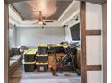 Partially cluttered living room with gray walls, a tray ceiling, a ceiling fan, and wood-look floors at 1233 Bramley Ln, Deland, FL 32720