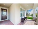 Cozy front porch with brick flooring, seating, and a decorative front door at 14345 Wabasso Loop, Winter Garden, FL 34787