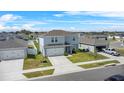 Aerial view of a two-story home with a two-car garage, in a residential community with well-maintained lawns at 1506 Finnigan Cir, Haines City, FL 33844