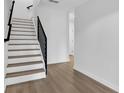 Modern staircase boasts light wood stairs, sleek black railing, and minimalist design at 1602 Park Lake St # 2, Orlando, FL 32803