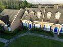 Aerial view of tan townhomes with dormer windows, manicured lawns, and blue shutters at 1920 Island Walk Dr, Orlando, FL 32824