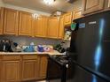 Functional kitchen featuring wooden cabinets and modern black appliances at 227 Strawberry Ln, Daytona Beach, FL 32117