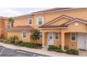 Attractive exterior of a two-story townhome featuring a red tile roof and a tidy, landscaped front yard at 2653 Roadster Ln, Kissimmee, FL 34746