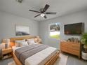 Bright bedroom featuring a ceiling fan, neutral paint, a large window, and sleek wooden furniture at 2936 Woodcrest Ln, Lakeland, FL 33805