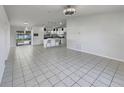 Open concept living room and kitchen with tiled floors, white cabinets and modern appliances and neutral paint at 2936 Woodcrest Ln, Lakeland, FL 33805