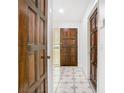 Hallway showing the interior of the home with neutral tile floors and wood doors at 3283 Pub Ln, Orlando, Fl, FL 32808