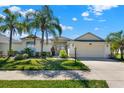 Attractive single-story home featuring a two-car garage, lush landscaping, and a well-maintained lawn at 3624 Belle Rose Dr, Leesburg, FL 34748