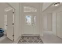 Bright foyer with decorative front door, tile floors, and transom window at 3624 Belle Rose Dr, Leesburg, FL 34748