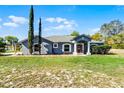 Well-maintained single-story home with vibrant green lawn, mature trees at 380 Dorset Ave, Deltona, FL 32738