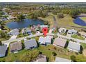An aerial view of a property featuring a scenic view and pond in a well-maintained neighborhood at 5414 Zinnia St, Leesburg, FL 34748