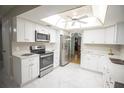Bright kitchen with stainless steel appliances, white cabinets, and marble tile flooring at 613 Andrew St, Altamonte Springs, FL 32714