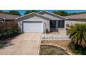 Charming one story home featuring attached one car garage and screened in porch, surrounded by a white picket fence at 790 Blake Ln, The Villages, FL 32162