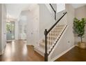Inviting entryway featuring hardwood floors, a staircase with white railings and a glimpse into the living area at 8549 Lovett Ave, Orlando, FL 32832