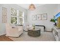 Cozy living room with neutral tones, stylish decor, hardwood flooring, and natural light from large windows at 8549 Lovett Ave, Orlando, FL 32832