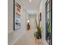 Elegant hallway featuring modern art, a decorative mirror, a sleek plant stand, and neutral decor at 909 Pearlwood Loop, Eagle Lake, FL 33839