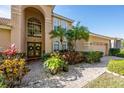 Inviting front entrance with double doors, mature landscaping, and brick walkway leading to the main door at 221 Calliope St, Ocoee, FL 34761