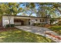 Inviting single-story home featuring a covered carport, brick accents, and a well-manicured lawn at 3903 Mockingbird Ln, Orlando, FL 32803