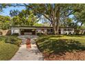 Charming single-story home with a covered carport, brick accents, and a well-manicured lawn with mature shade trees at 3903 Mockingbird Ln, Orlando, FL 32803